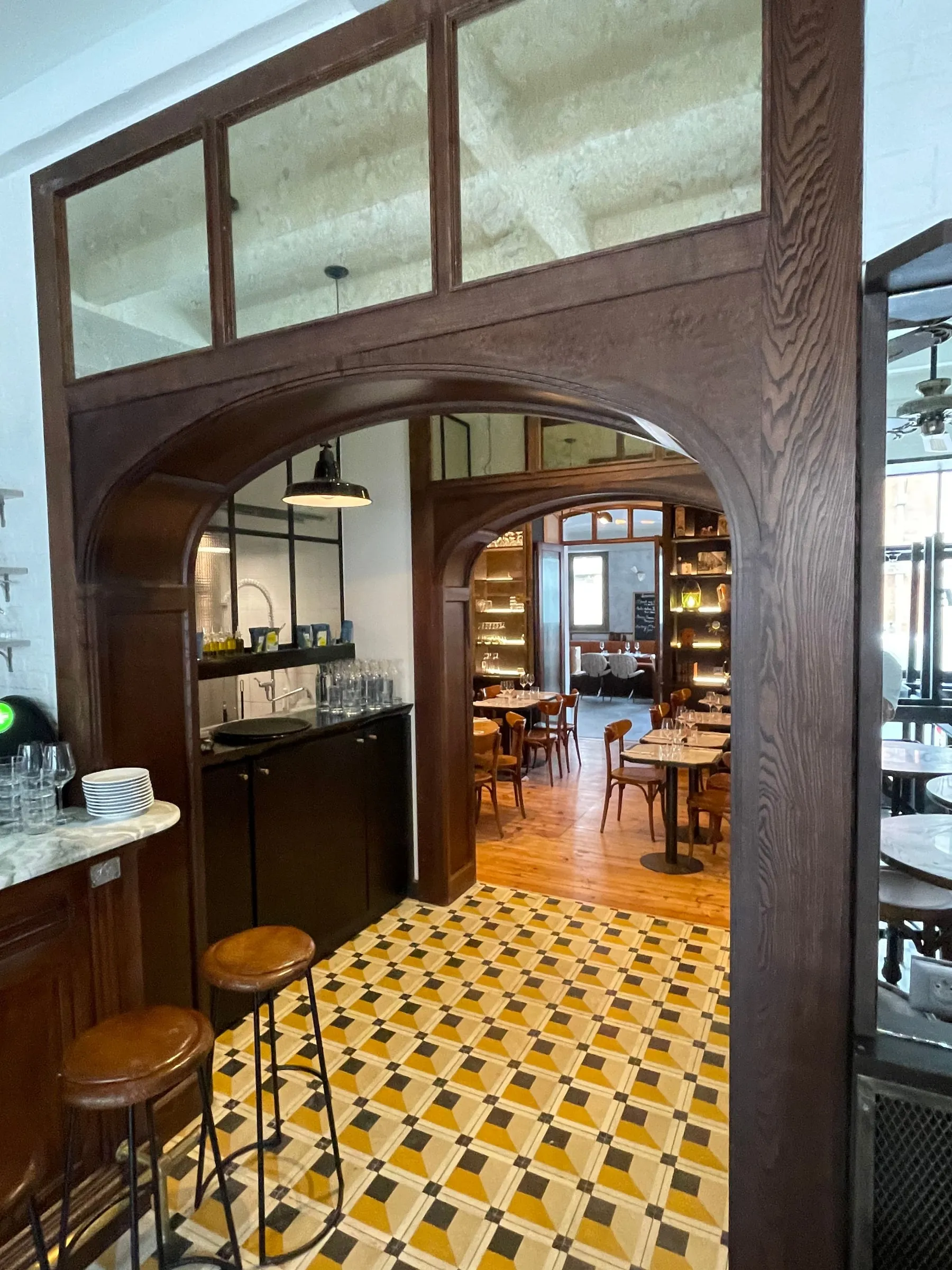 Encadrement de porte cintré en bois et verrière, réalisés sur mesure pour un restaurant